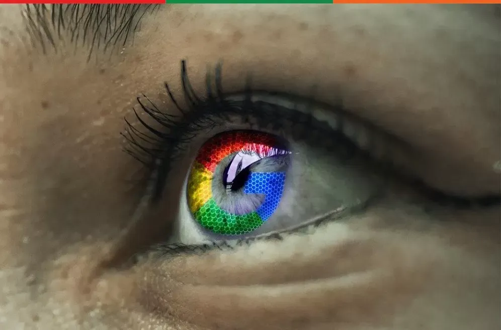 A close-up of an eye with the Google colours reflected in it
